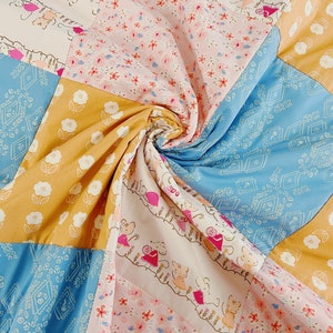 May include: A patchwork quilt with a variety of floral patterns in shades of blue, yellow, pink, and white. The quilt is made of different fabrics and textures, creating a unique and interesting design.
