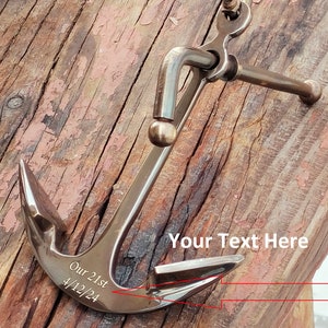 May include: A bronze anchor with a ring at the top and a curved arm, set against a weathered wooden background. The anchor has the engraved text "Our 21st 4/12/24". The words "Your Text Here" are also visible.