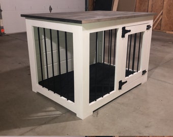 May include: A white wooden dog crate with a gray top and black bars. The crate has two doors with black hinges and a black floor. The crate is designed to provide a safe and comfortable space for a dog.
