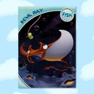 May include: A trading card featuring a cartoon illustration of a devil ray fish with orange and white markings. The card has a blue border and the text "DEVIL RAY" and "FISH" in a white circle.