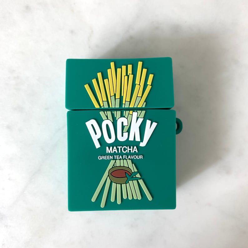 May include: Green case for wireless earbuds, designed to resemble a box of Pocky Matcha green tea flavored snacks. The case features the Pocky logo and illustrations of the snack sticks. The case is open, revealing the interior.