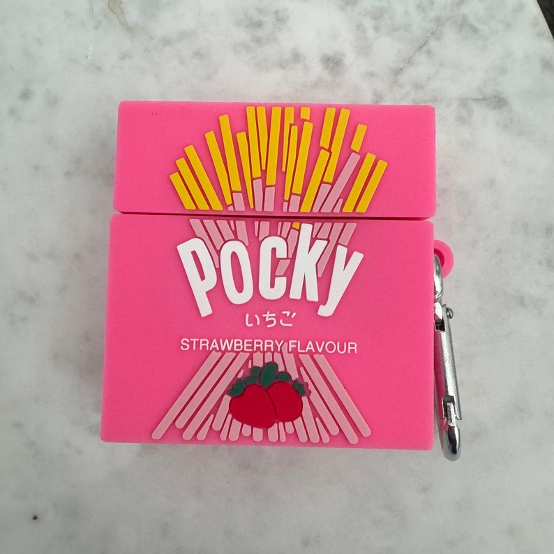 May include: Pink Pocky-themed AirPod case with a silver carabiner clip. The case features the Pocky logo in white, Japanese characters, and the words "Strawberry Flavour." The top of the case has a design of yellow biscuit sticks.