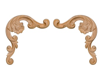 Könnte beinhalten: Ein Paar verzierte, dekorative Holzecken mit floralem Design. Die Klammern sind hellbraun und haben ein geschnitztes, rollenförmiges Muster.