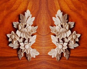 May include: Two identical wooden floral appliques with intricate carvings. Each applique features a cluster of three flowers with detailed leaves. The flowers have a raised center and delicate petals.