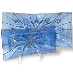 May include: Two rectangular glass serving dishes with a blue and white swirl pattern. The larger dish has a gold rim and the smaller dish has a blue rim.