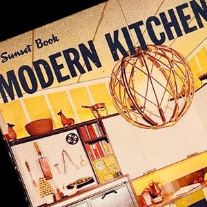 Puede incluir: Una portada de libro vintage titulada "Sunset Book MODERN KITCHEN" con una escena de cocina retro. La portada es beige con texto azul marino. Una lámpara dorada con estructura de alambre cuelga en primer plano. La cocina tiene armarios y estantes amarillos y blancos con objetos decorativos.