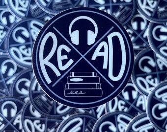 Op de afbeelding: Een close-up van een stapel blauwe en witte stickers met het woord "READ" in een gestileerd lettertype. De stickers tonen een koptelefoon met een doorgestreept stapeltje boeken. De stickers zijn perfect voor boekenliefhebbers en luisterboekliefhebbers.