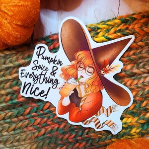 Puede incluir: Una bruja con un sombrero marrón y gafas bebe un latte de especias de calabaza. La pegatina dice "Pumpkin Spice & Everything Nice!"