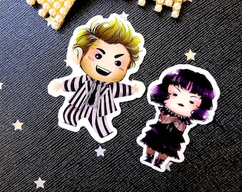 May include: Two cartoon character stickers, one of a man in a black and white striped suit with blonde hair and a mischievous grin, and the other of a woman with purple hair wearing a black dress and a white collar.