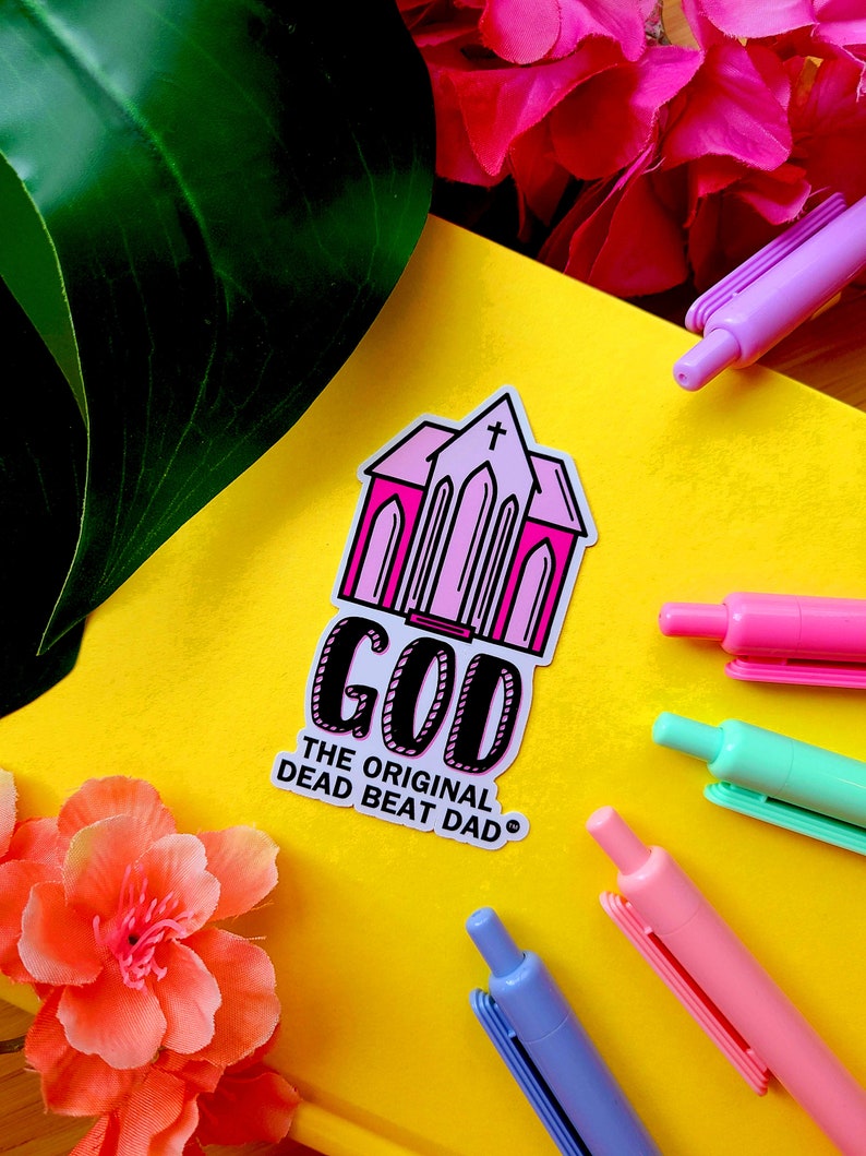 A sticker of a pink church with text that reads "GOD the original dead beat dad tm"