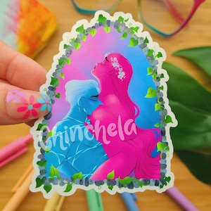May include: A sticker featuring a blue and pink illustration of two figures embracing. The figures are surrounded by a border of green leaves and white stones. The text "Chinchela" is written in white cursive letters at the bottom of the sticker.