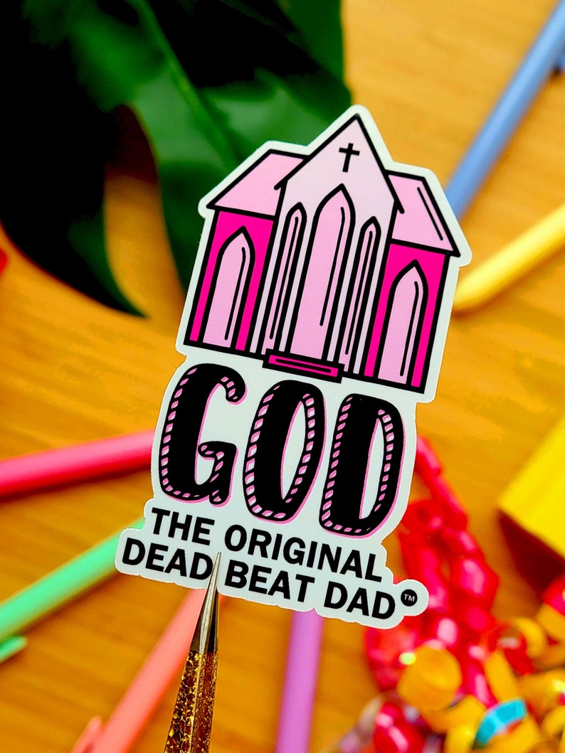 A sticker of a pink church with text that reads "GOD the original dead beat dad tm"