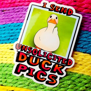 May include: A white sticker with a cartoon duck and the text "I send unsolicited duck pics". The sticker is on a multi-colored background.