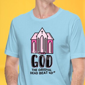 May include: A light blue t-shirt with a pink church graphic and the text "GOD THE ORIGINAL DEAD BEAT DAD".