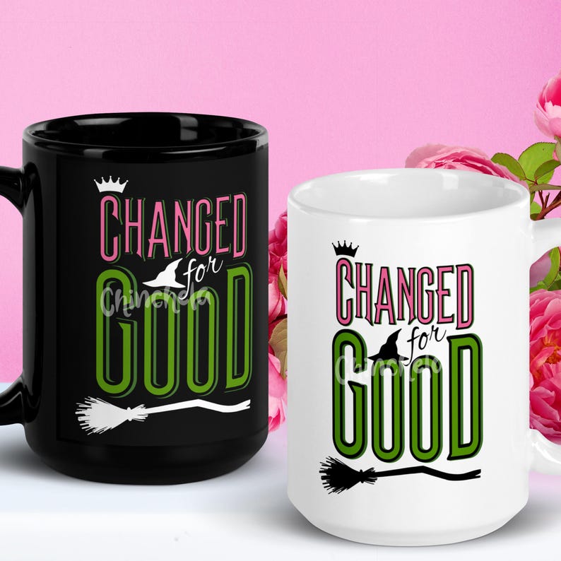 Pode incluir: Duas canecas de caf&eacute; com fundos preto e branco. Ambas as canecas apresentam o texto "CHANGED for GOOD" em letras rosa, verde e preta com um gr&aacute;fico de chap&eacute;u de bruxa e vassoura.