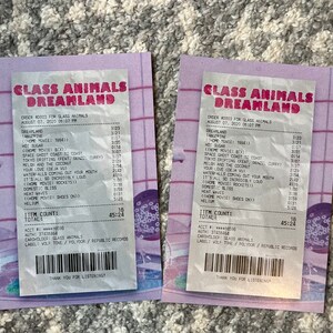 May include: Two receipts from Glass Animals Dreamland concert. The receipts list the setlist for the concert, including songs like "Dreamland", "Tangerine", "Hot Sugar", "Space Ghost Coast to Coast", "Your Love (Deja Vu)", "Melon and the Coconut", "Tokyo Drifting", "It's All So Incredibly Loud", "Waterfalls Coming Out Your Mouth", "Domestic Bliss", "Heat Waves", "(Home Movie: Shoes On)", and "Helium". The receipts also include the total cost of the concert, which is $45.24.