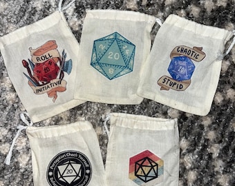 May include: Five white drawstring bags with different designs featuring a 20-sided die. The designs include "Roll Initiative", "Perception Check Yourself Before You Wreck Yourself", "Chaotic Stupid", and two different dice designs.