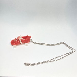 May include: A red plastic roller skate charm on a silver chain necklace.