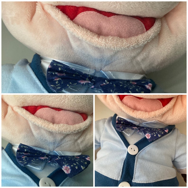 May include: A plush toy with a blue and white patterned bow tie. The toy has a light blue shirt and a blue cardigan. The toy has a pink tongue and a red mouth.