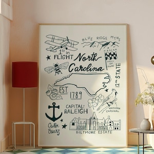 Peut inclure: Une affiche encadrée avec une carte dessinée à la main de la Caroline du Nord. La carte comprend des illustrations d'un biplan, de montagnes, d'une abeille, de myrtilles, d'une ancre et du Biltmore Estate. Le texte comprend "1st in Flight" et "Capital: Raleigh."