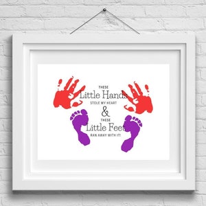 May include: A framed print with red handprints and purple footprints. The text reads "THESE Little Hands STOLE MY HEART & THESE Little Feet RAN AWAY WITH IT!"