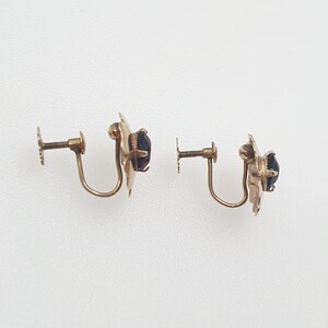 May include: A pair of gold-tone clip-on earrings with black stones.