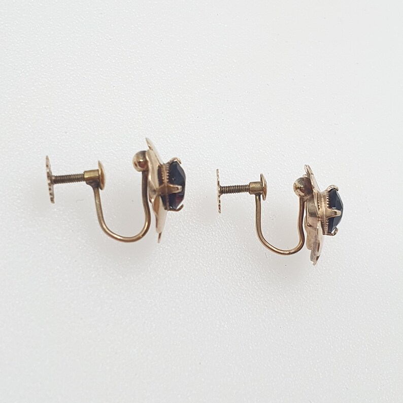 May include: A pair of gold-tone clip-on earrings with black stones.