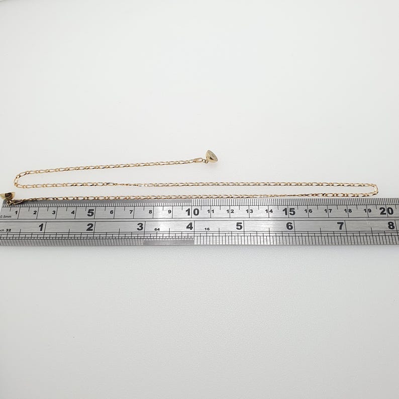 May include: A gold chain necklace measuring 18 inches in length. The chain is a delicate, fine link style.