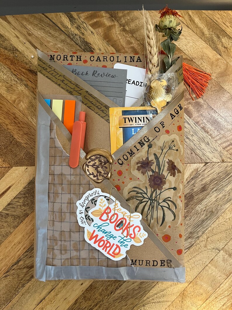 K&ouml;nnte beinhalten: Ein handgefertigtes Geschenkpaket zum Thema B&uuml;cher mit den Worten "North Carolina Book Review" und "Coming of Age". Enth&auml;lt einen Teebeutel, Haftnotizen, ein Wachssiegel und einen Aufkleber mit der Aufschrift "Books change the world".