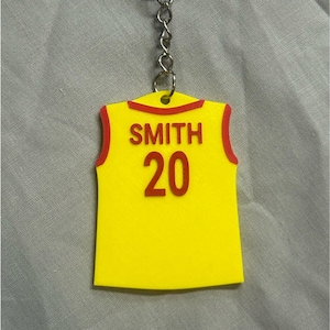 May include: Yellow jersey keychain with red trim, featuring the name "SMITH" and the number "20" in red.