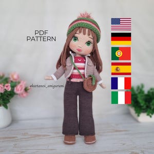 Könnte beinhalten: Handgemachte Amigurumi-Puppe mit grün-brauner Mütze, gestreiftem Oberteil, beiger Jacke und brauner Hose. Die Puppe hat lange braune Haare und eine kleine braune Tasche. Der Text "PDF PATTERN" ist sichtbar.