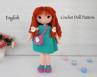 May include: A handmade crochet doll with red yarn hair, wearing a teal dress and purple shoes. The doll has a small pink purse with a white flower. The text "English" and "Crochet Doll Pattern" are visible.