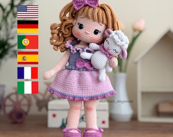 May include: A handmade crochet doll with curly brown hair, a purple bow, and a pink dress. The doll is holding a small white sheep. The doll's shoes and dress are trimmed with purple. The doll is approximately 10 inches tall.