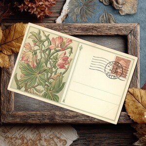 May include: Vintage postcard featuring a floral illustration in shades of pink and green. The postcard has a postage stamp and postmark. The postcard is set in a rustic wooden frame, surrounded by dried leaves and decorative paper.