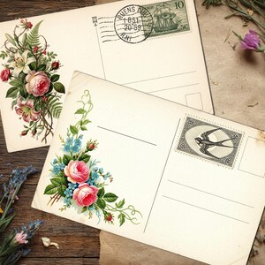 May include: Two vintage postcards with floral illustrations, featuring pink roses and blue flowers. One postcard has a stamp with a ship, the other a stamp with a bird. Dried flowers and herbs surround the postcards on a wooden surface.