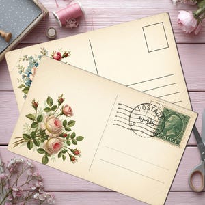 May include: Two vintage postcards with floral designs, one featuring roses and the other blue flowers. A green postage stamp is visible on one postcard. The scene includes scissors, spools of pink thread, and decorative elements.
