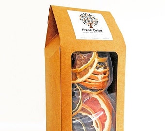 May include: A box of dried citrus fruit slices. The box is made of brown cardboard and has a clear window on the front. The fruit slices are a mix of orange, grapefruit, and lime. The box has a label that says "Fresh Dried" with a tree logo.