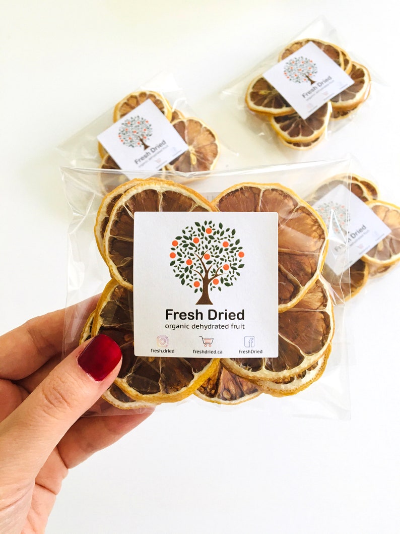May include: A clear plastic bag filled with dried lemon slices. The bag has a label that says "Fresh Dried organic dehydrated fruit" and includes social media icons and website information.