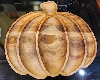 May include: A wooden pumpkin-shaped serving dish with four sections. The dish is made of light brown wood with a natural grain pattern.