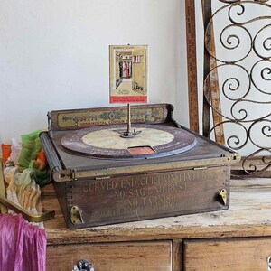 May include: Antique wooden curtain fixture with a rotating display and a sign that reads "CURVED END CURTAIN FIXTURE NO SAG NO RUST NO TARNISH JAMES H. BOYE MANUFACTURING CO. N.Y."