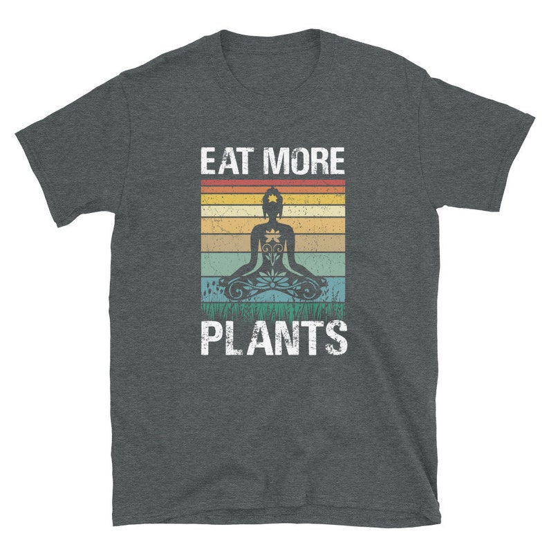 Pu&ograve; includere: Una t-shirt grigio scuro melange con una grafica vintage di una persona che medita con il testo "Eat More Plants" in bianco.