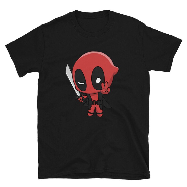 Puede incluir: Camiseta negra con una imagen de dibujos animados de Deadpool sosteniendo una espada y haciendo un signo de paz.