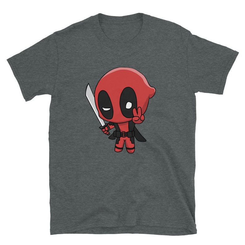 Puede incluir: Una camiseta gris oscuro jaspeada con una imagen de dibujos animados de Deadpool, un superh&eacute;roe, sosteniendo una espada y haciendo un signo de paz. La imagen est&aacute; en estilo chibi, lo que significa que es una caricatura con una cabeza grande y un cuerpo peque&ntilde;o.