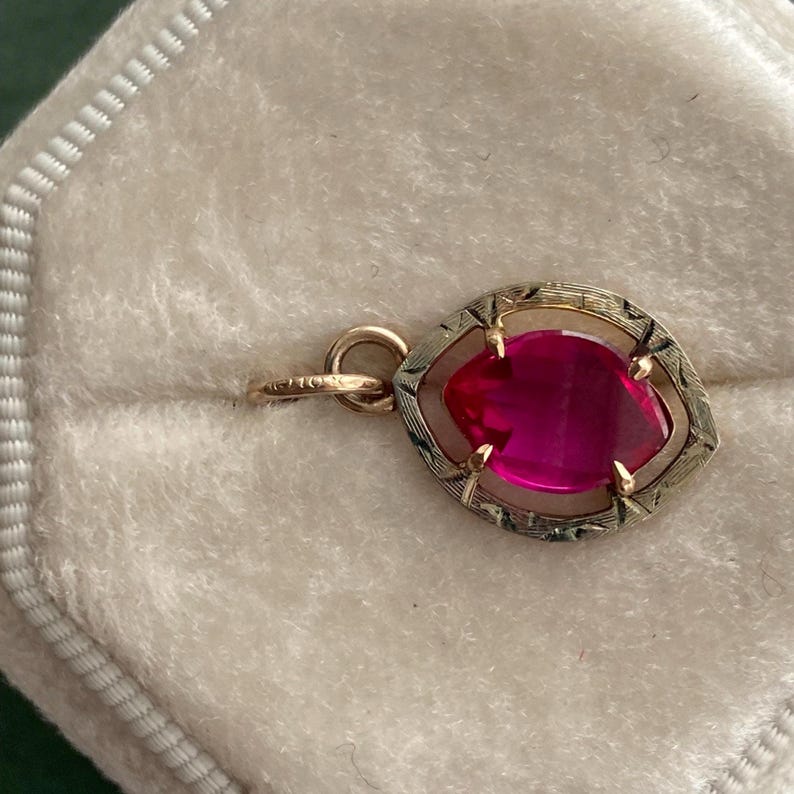 Charm in white and yellow gold shown sideways to illustrate the 10k mark from the stickpin that was preserved in using the stickpin for the bail.