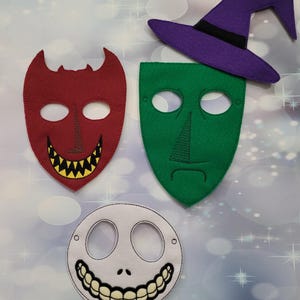 May include: Felt masks and a witch hat in a Halloween theme. The masks are red, green, and white, with black embroidered details. The witch hat is purple with a black band. Perfect for costume parties.