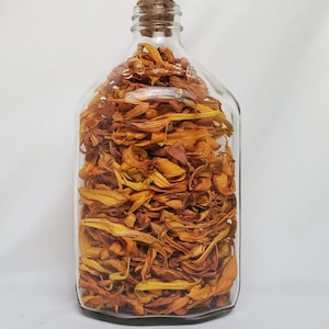 Peut inclure: Une bouteille en verre transparente avec un bouchon en liège remplie de pétales de fleurs séchées orange et jaunes.
