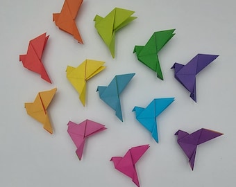 May include: A collection of 12 origami paper birds in a rainbow of colours, including red, orange, yellow, green, blue, indigo, and violet.