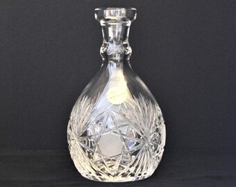 May include: A clear glass decanter with a star-shaped pattern and a gold label that reads "Made in Czechoslovakia".