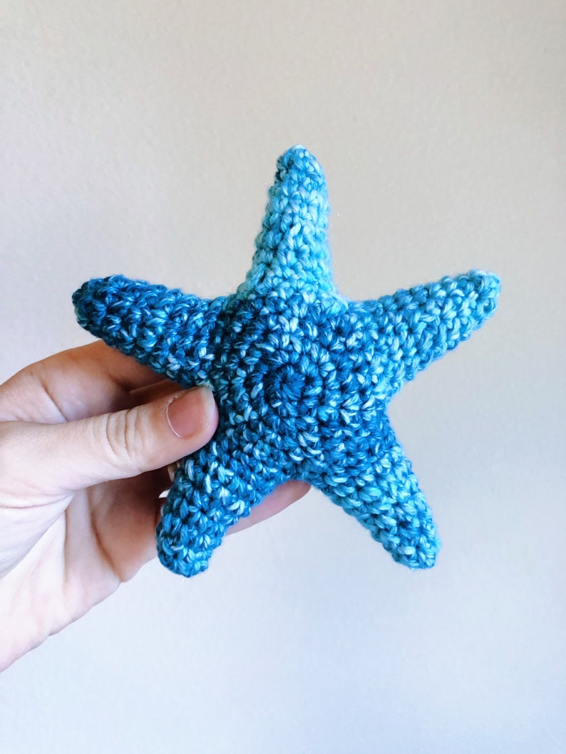 May include: A blue crocheted starfish with a gradient of color from light blue to dark blue.