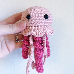 May include: A crocheted pink and red jellyfish toy with black eyes.